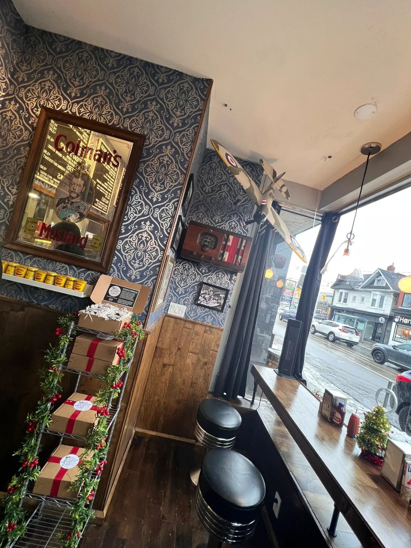 A model Spitfire hangs above the window stools, with the street beyond.